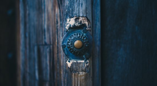 Старинный дверной металлический звонок на синей деревянной двери